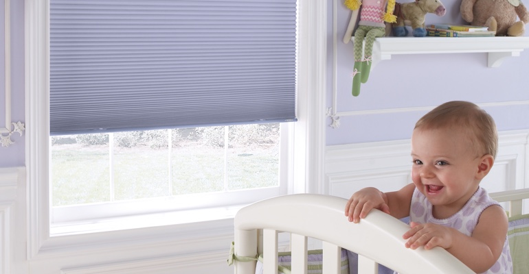 Raleigh infant's nursery with honeycomb shades.